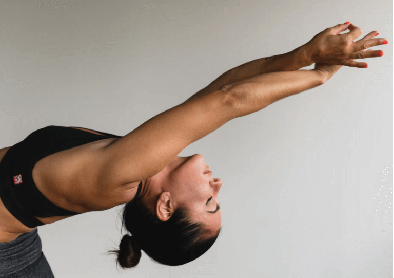 femme qui fait du yoga arpès une séance sur un tapis d'acupression